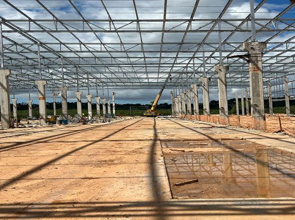 Vista interna de galpão com a estrutura metálica de cobertura montada
